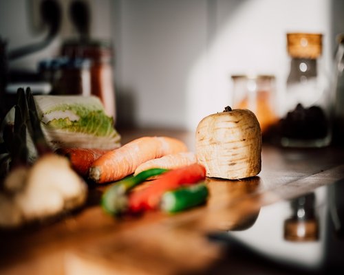 A variety of fresh vegetables and legumes on a rustic kitchen counter